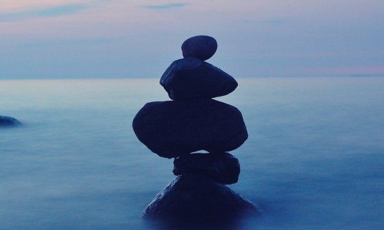 Piedras una encima de otra sobre el agua en la bruma de la noche.