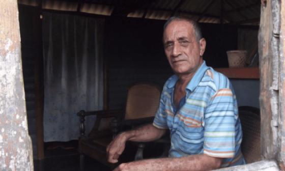 Poeta cubano Delfín Prats asomado a una ventana.