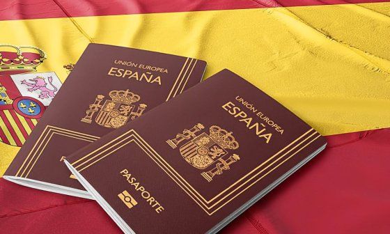 dos pasaportes españoles encima de una bandera española.