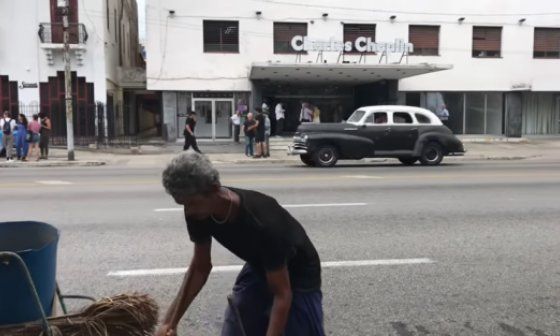 Hombre limpiando la calle frente al cine Charles Chaplin