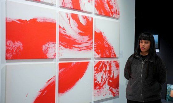 La artista visual cubana Su_ayma Parra junto a su pieza "Gajes del oficio" (2024).