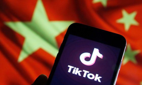 Teléfono con el ícono de TikTok y bandera china al fondo.