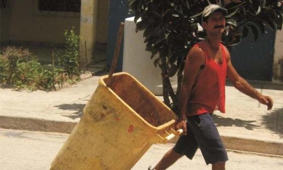Trabajador de servicios comunales arrastra un tanque. Foto: Francis Sánchez