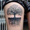 Tatuaje de un árbol en la pierna.